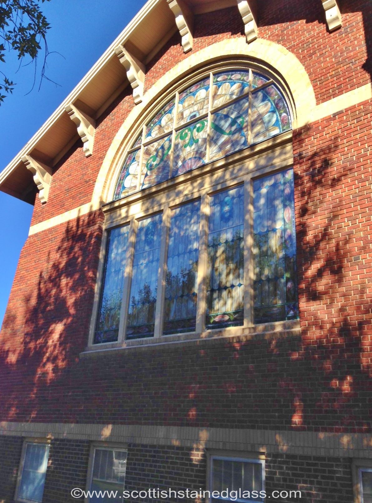 Basement stained glass window in a historic Houston home with visible cracks and deterioration